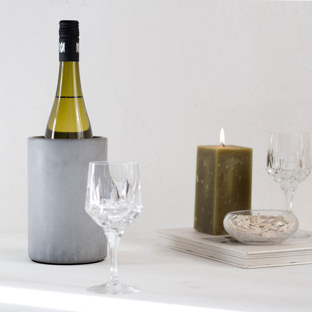 Flaschenkühler aus Beton mit einer eleganten Weinflasche.