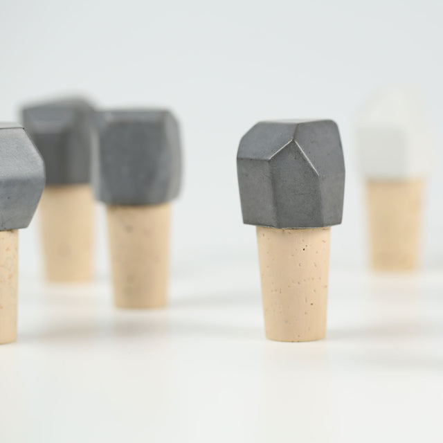 Viele Flaschenverschlüsse aus weißem und grauem Beton mit Kork