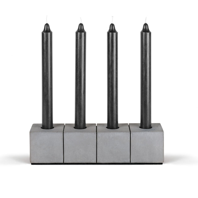Kerzenhalter aus dunkelgrauen Beton mit vier schwarzen Stabkerzen