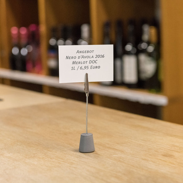 Moderner Betonzettelhalter mit einer nützlichen Krokodilklemme im Weinladen
