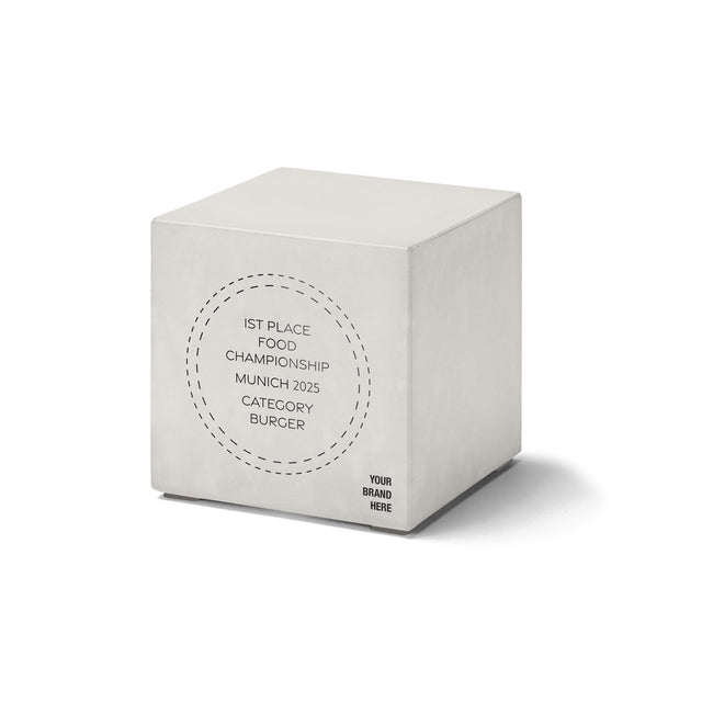 Minimalistischer Betonwürfel-Award mit rundem Schriftmotiv „1st Place Food Championship Munich 2025“.