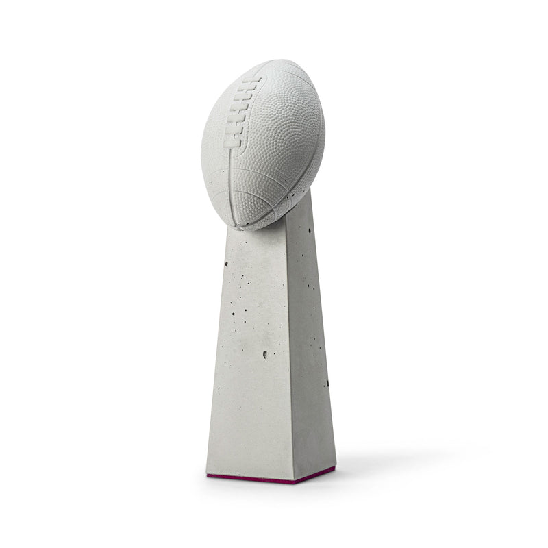 Ein einzigartiger Beton-Award, dessen Oberteil die Form eines Footballs hat und eine stelenförmige Basis besitzt