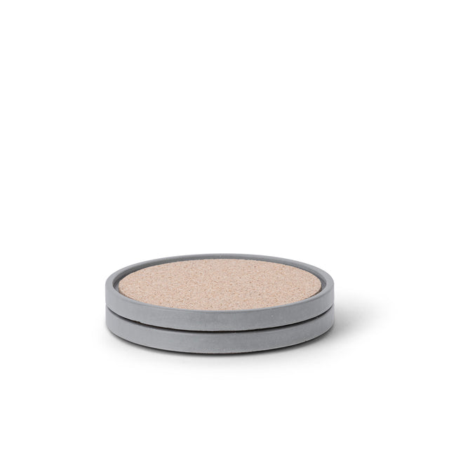 Zwei runde Beton-Untersetzer in Dunkelgrau mit Korkeinlage, minimalistisch gestapelt