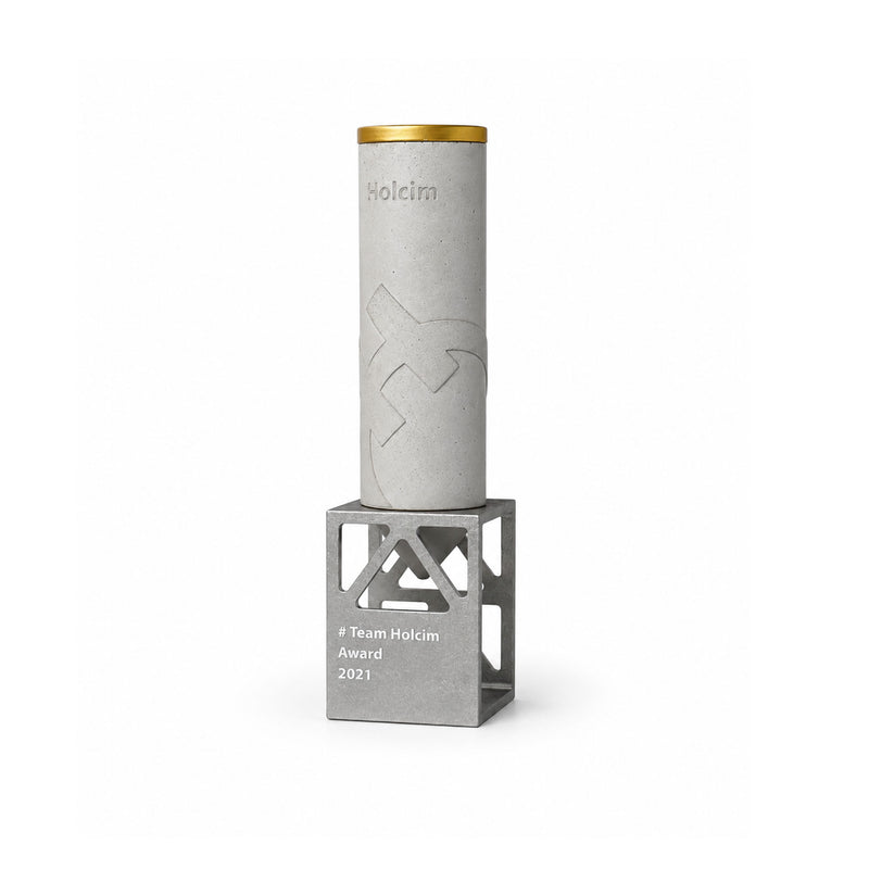 Holcim Team Award 2021: Betontrophäe mit goldenem Ring auf offenem Metallsockel