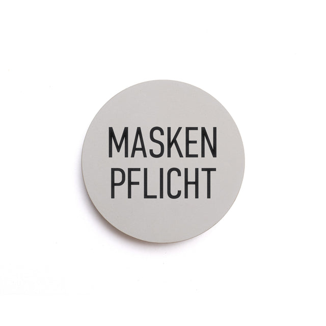 Hinweisschild aus Beton mit dem Text: MASKEN PFLICHT