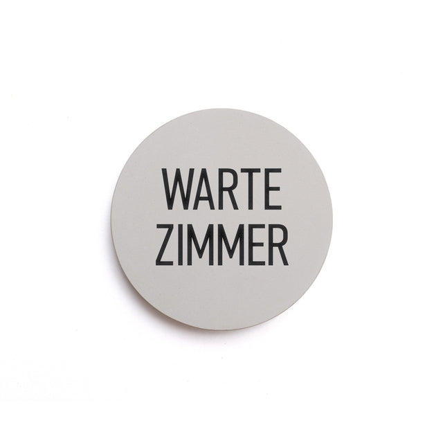 Hinweisschild aus Beton mit dem Text: WARTE ZIMMER