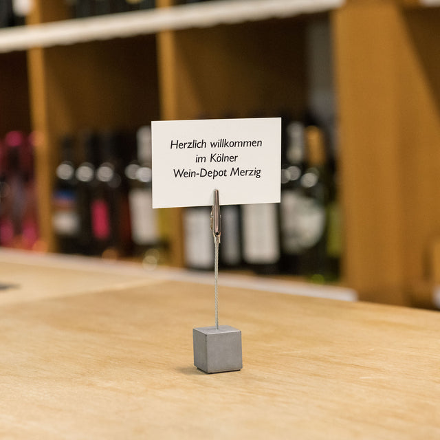Kubischer Betonzettelhalter mit einer nützlichen Krokodilklemme im Weinladen