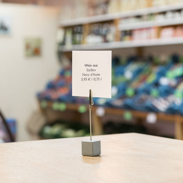 Innovativer Betonzettelhalter mit einer Krokodilklemme im Weinladen