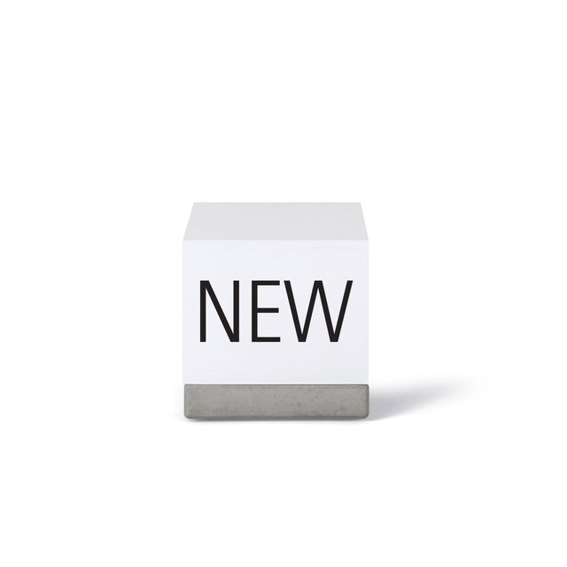 Notizblock "NEW NOTES" auf einem Sockel aus Beton